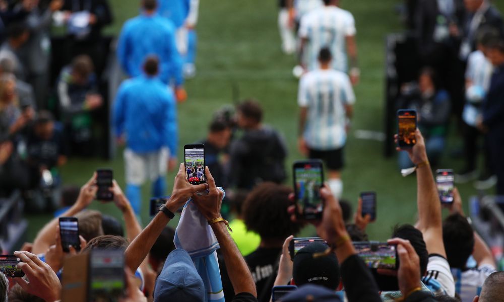 Stadium fans holding phones, interacting with live event content