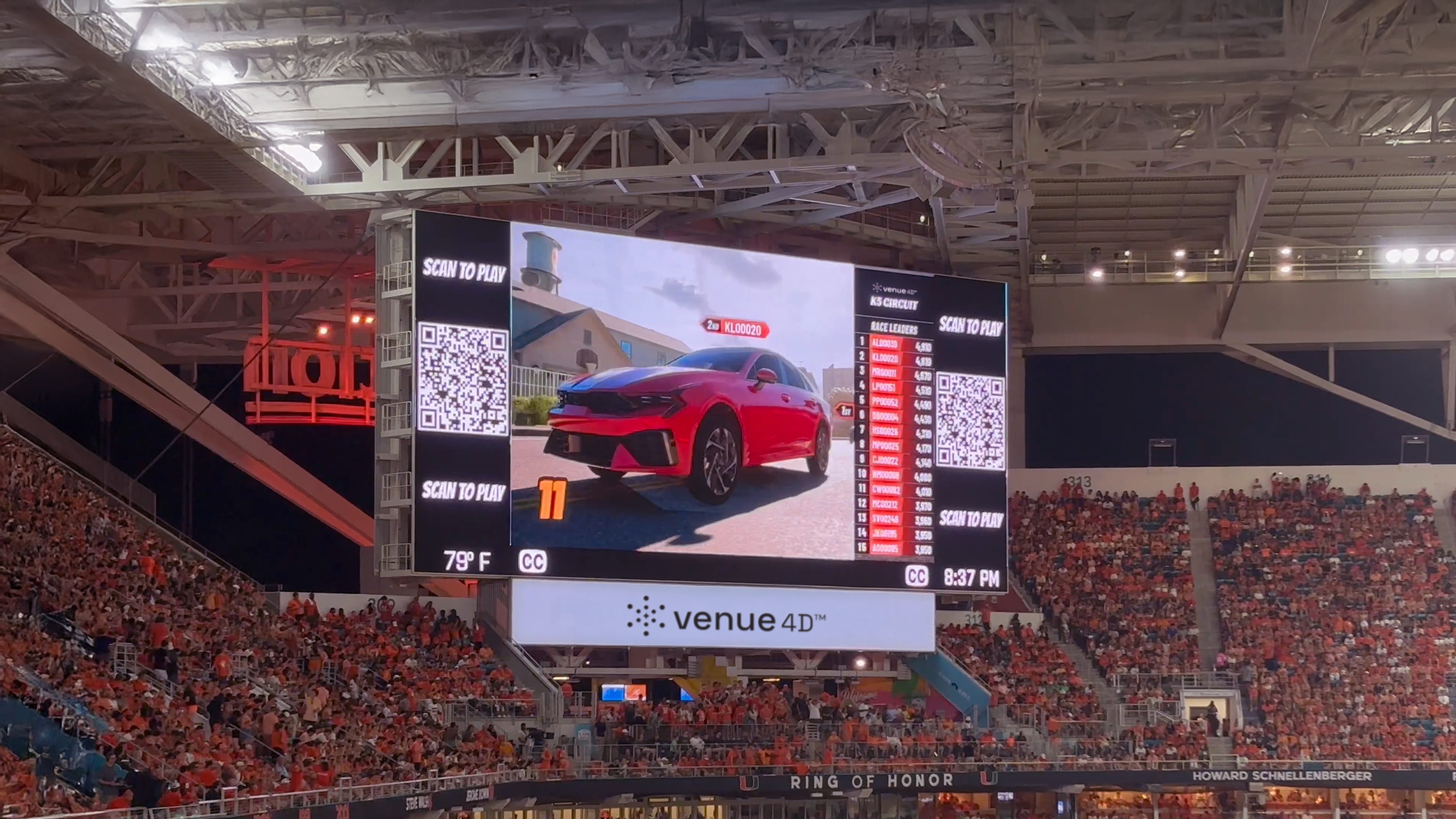 Fans participate in a live interactive race powered by venue4D™ at a packed college football stadium, featuring a real-time leaderboard displayed on the main videoboard.